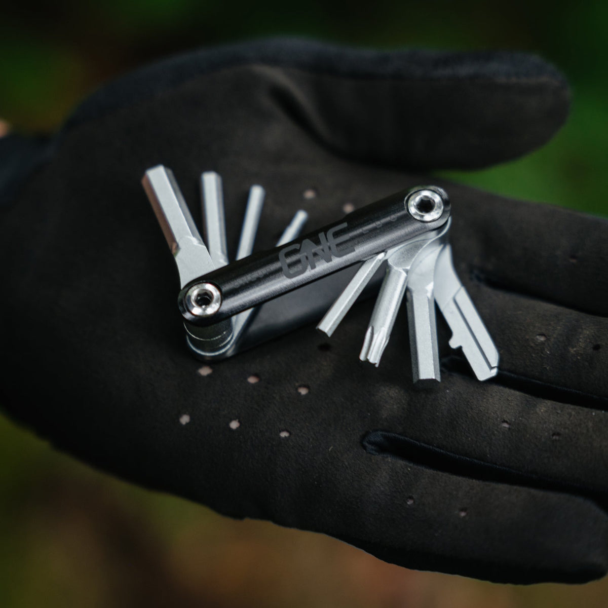 Open OneUp EDC multi-tool held in a glove