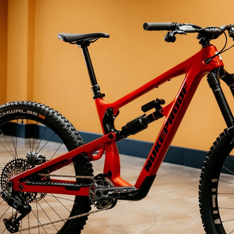 Red mountain bike on a concrete floor with a yellow wall background