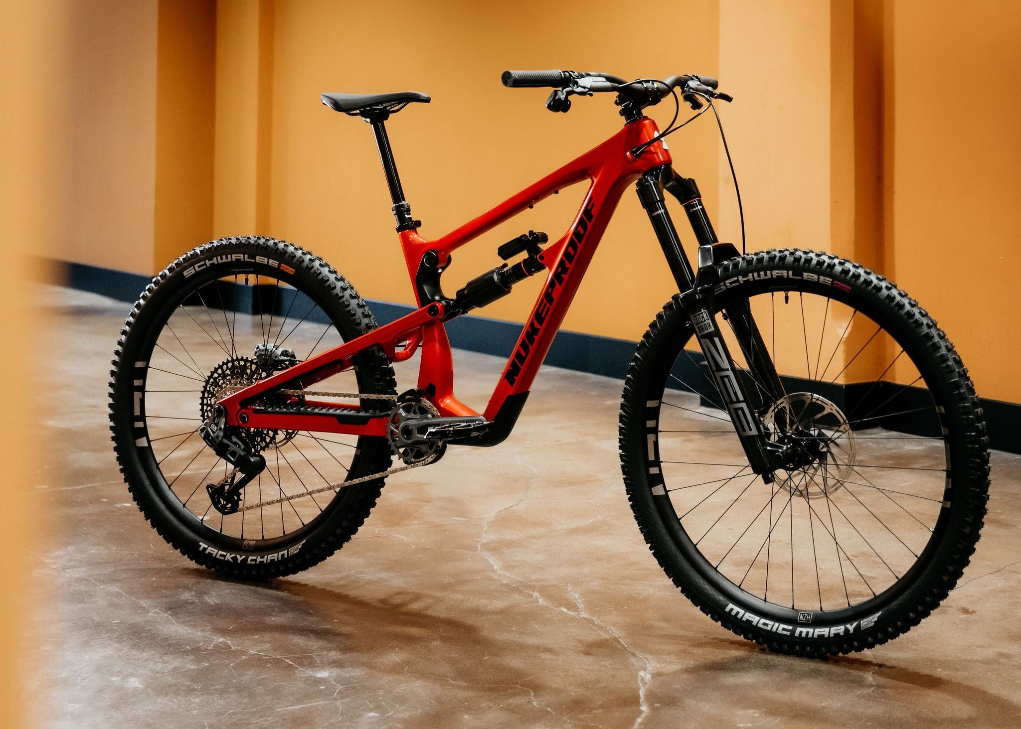 Red mountain bike on a concrete floor with a yellow wall in the background