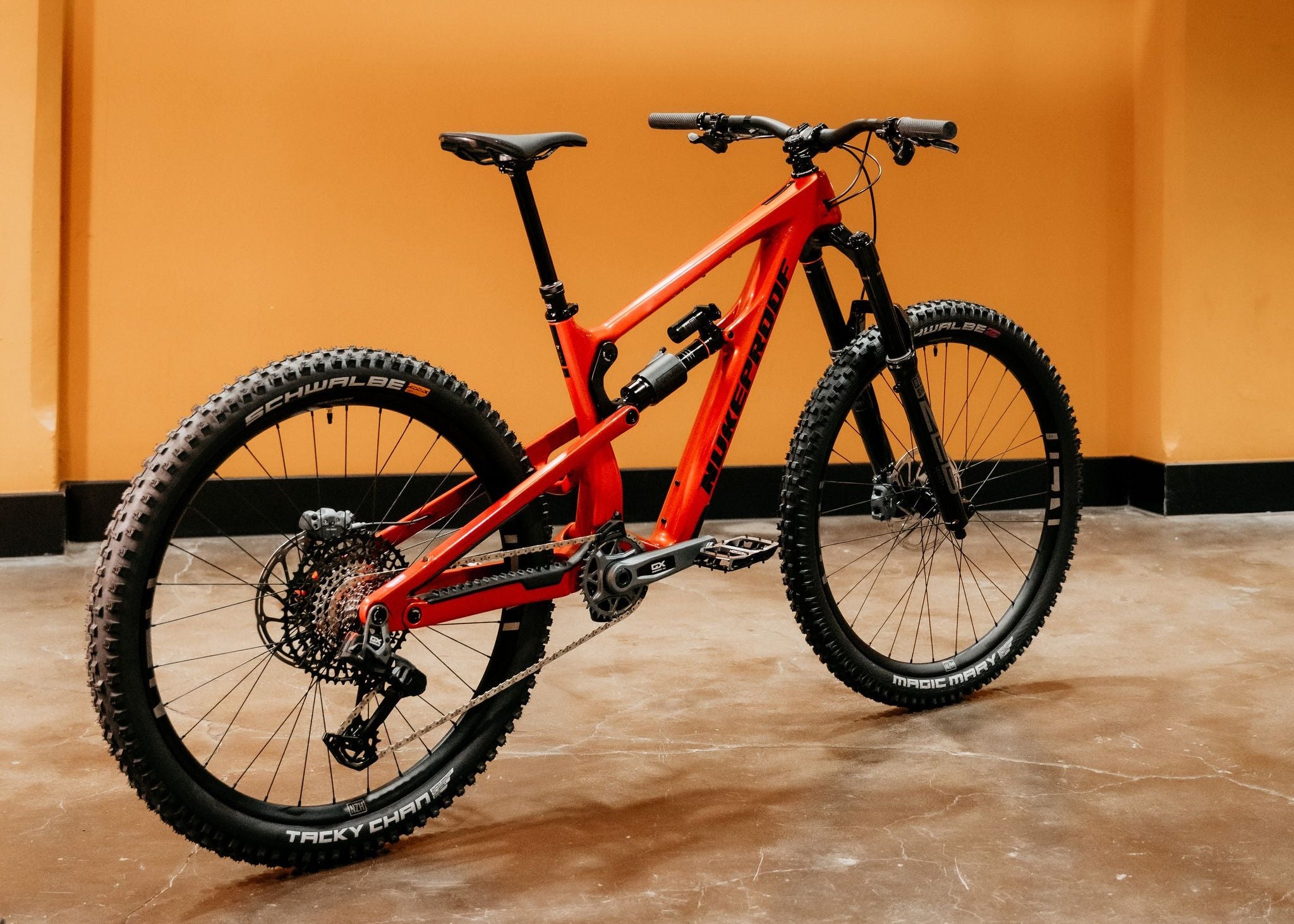 Red mountain bike on a concrete floor with an orange wall background