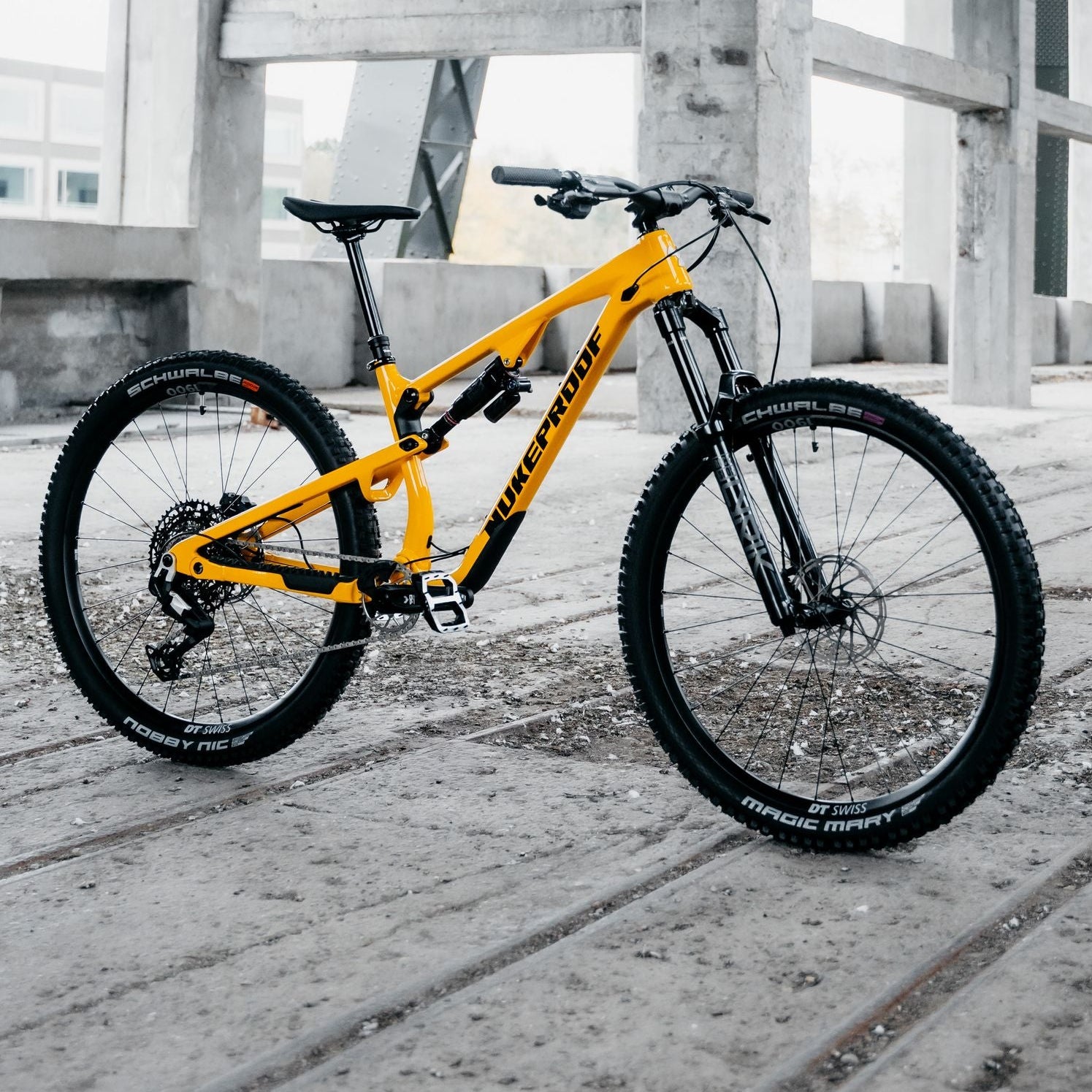 Yellow mountain bike on a concrete surface with industrial background