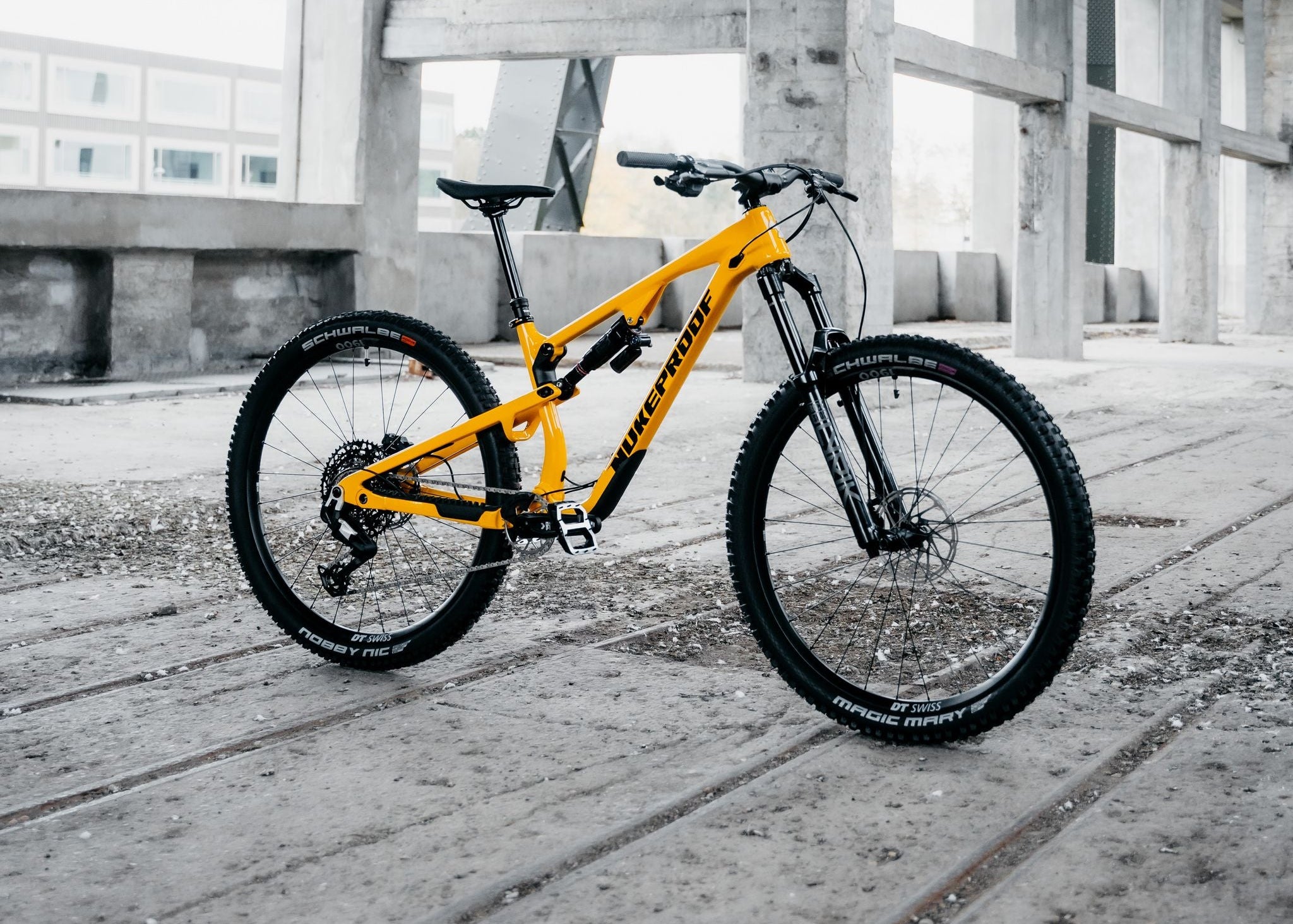 Yellow bicycle on a concrete surface with industrial background