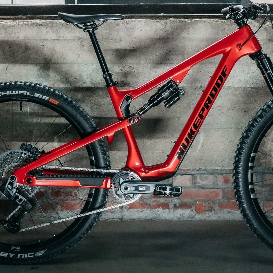 Red bicycle leaning against a wall with large windows in the background