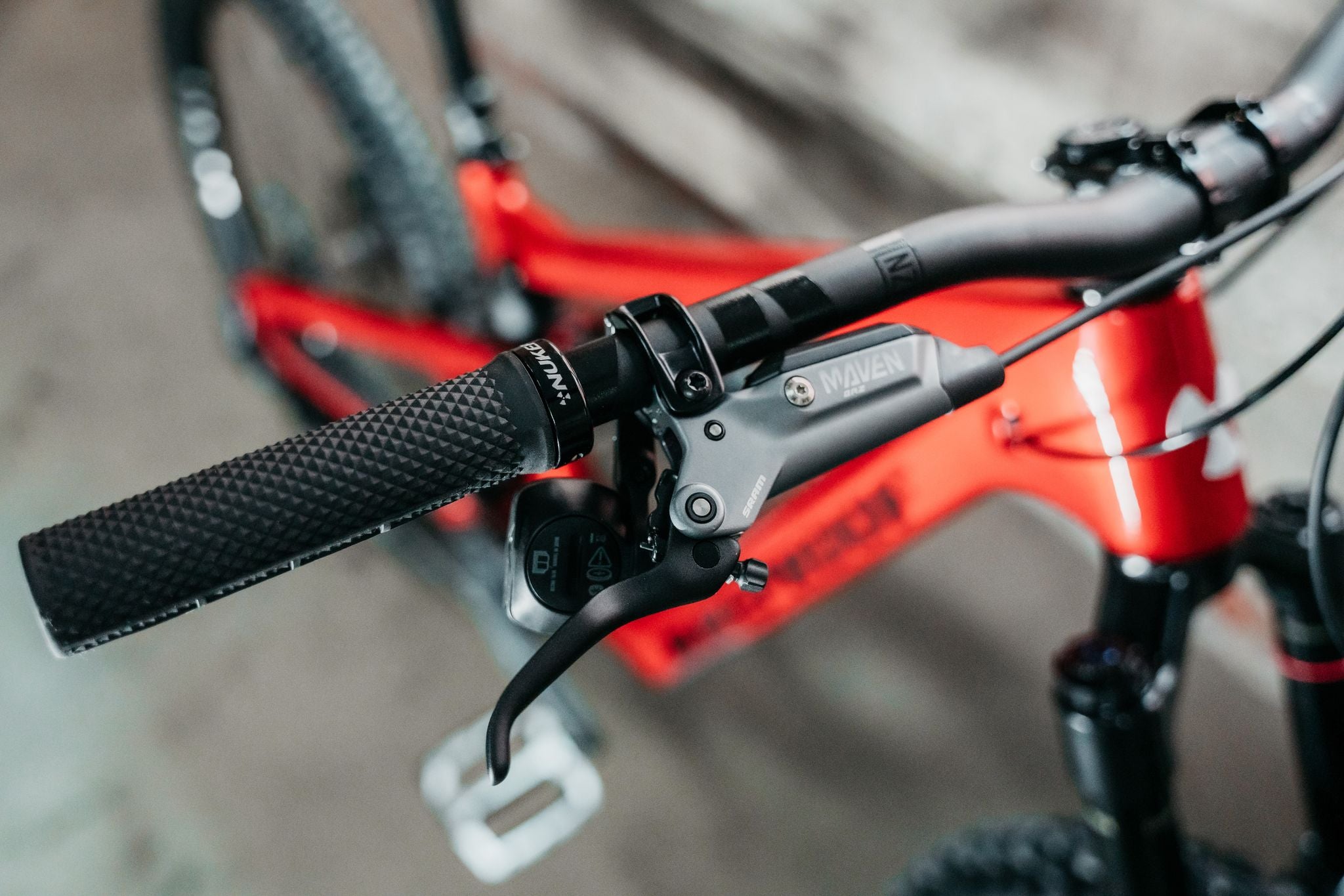 Close-up of bicycle handlebar with red frame and blurred background