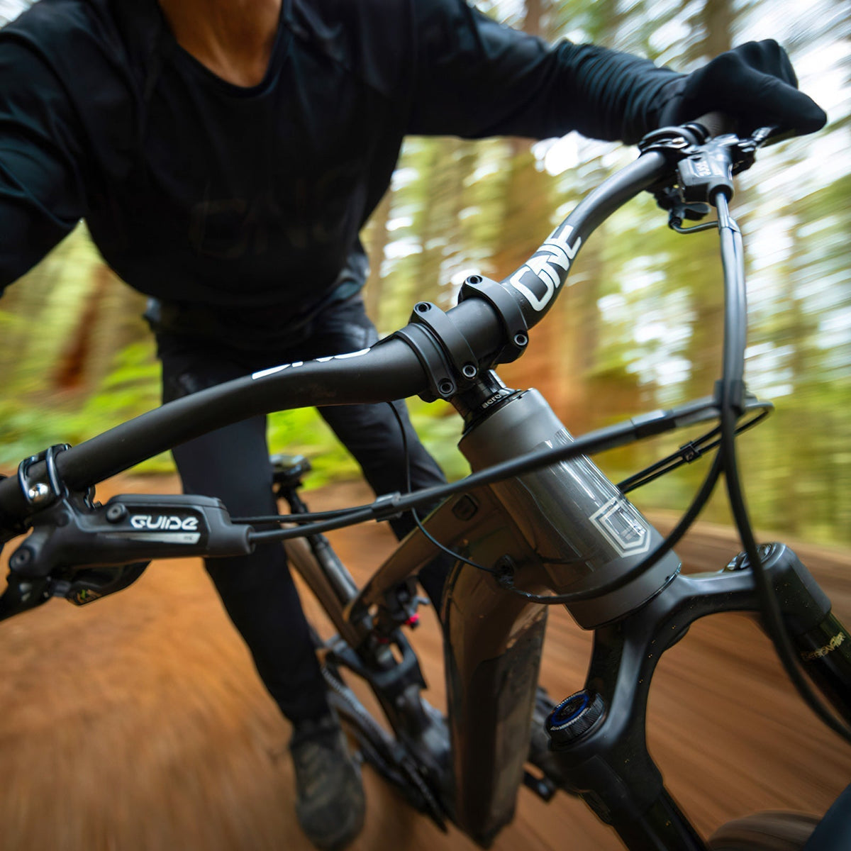 Rider holding a OneUp Carbon E-Bar on an e-bike