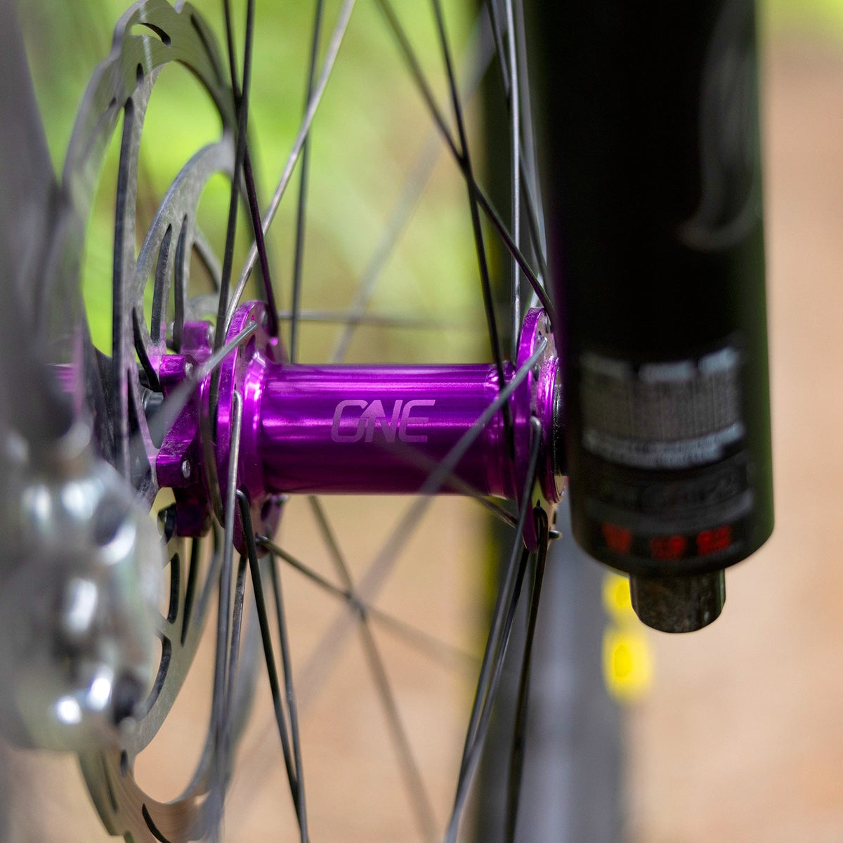 Purple OneUp Front Hub installed in a fork and wheel