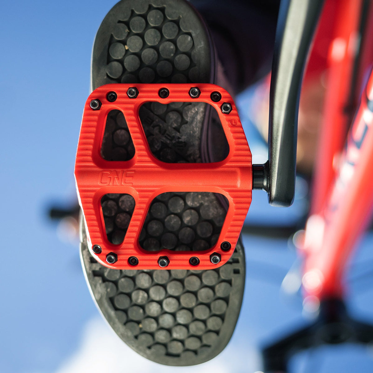 Red OneUp Small Composite Pedal against a smaller shoe sole