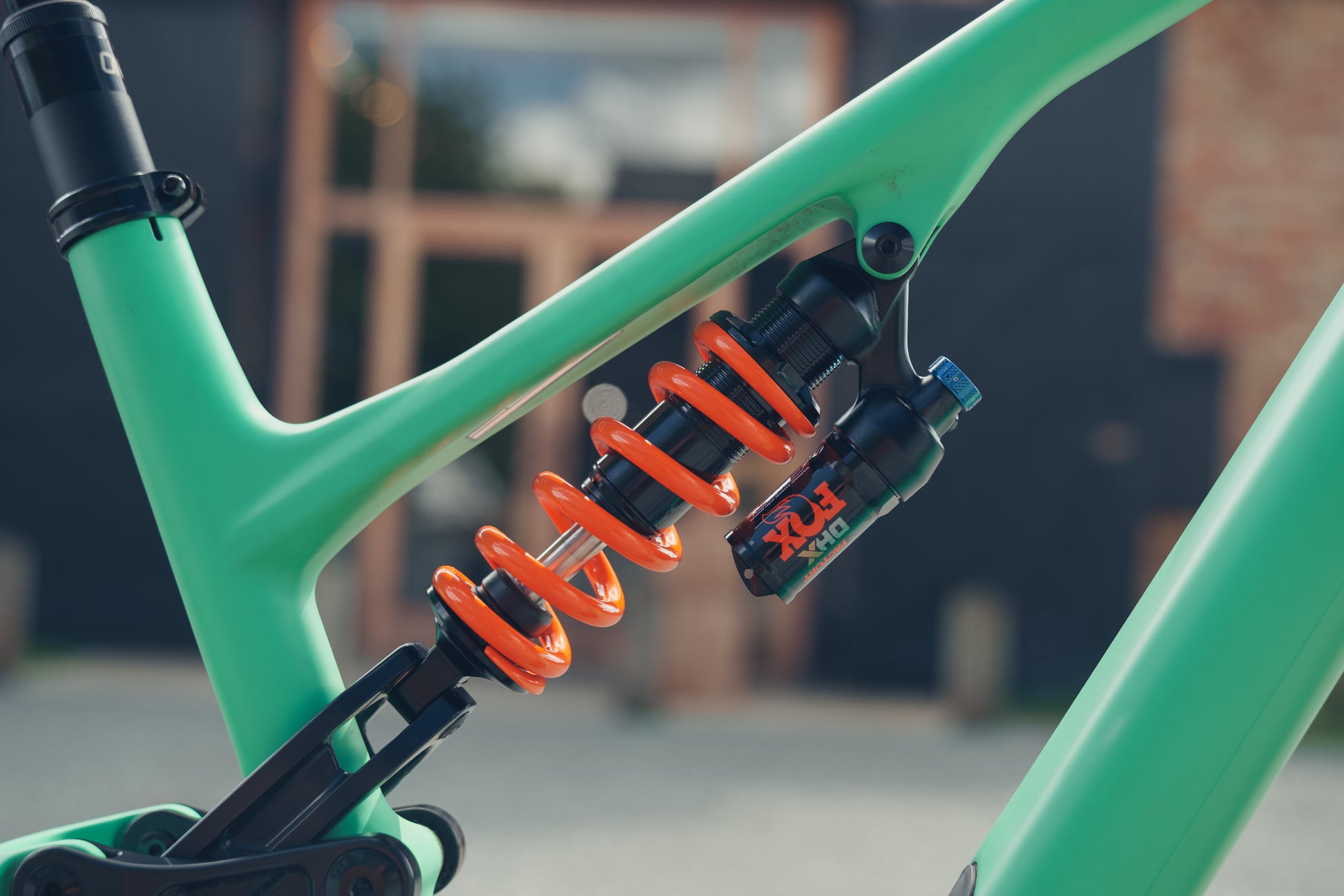 Close up of Bicycle Rear Suspension and Shock Absorber. Green bike with Orange Spring