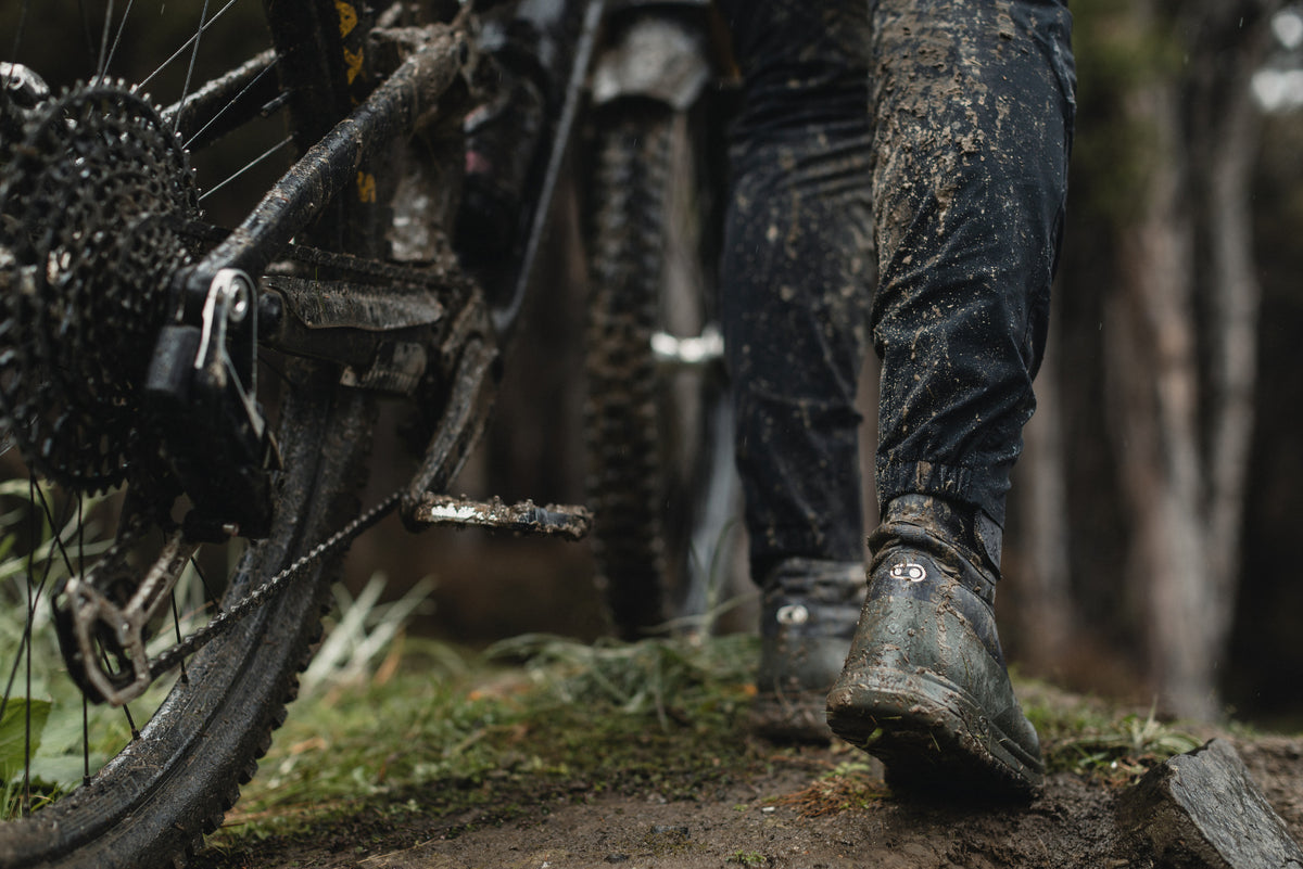 Mallet Trail Speed Lace Seal being used to walk on a muddy trail beside a bike