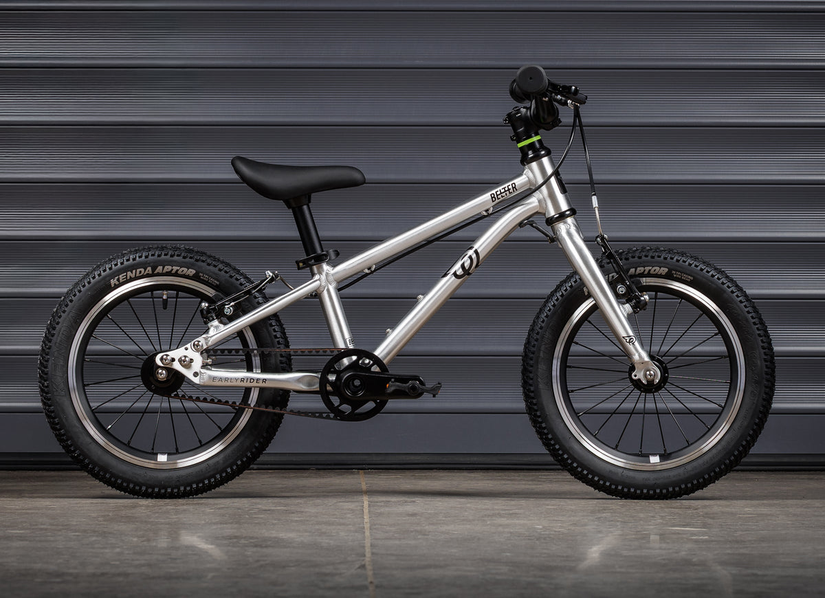 Early Rider Belter 14 in Brushed Aluminium - whole-bike drive-side profile against grey shutters