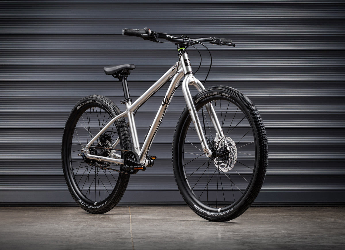 Early Rider Belter 24 in Brushed Aluminium - whole bike against shutters
