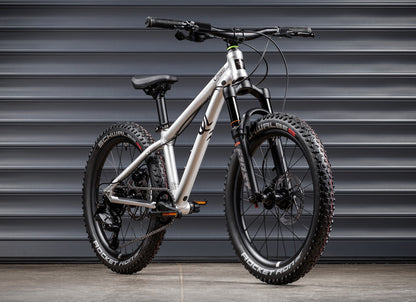 Early Rider Charger 20 in Brushed Aluminium - whole suspension bike against shutters