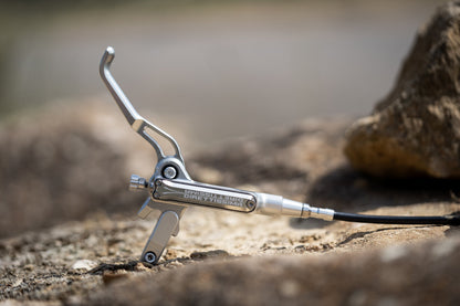 Silver Trickstuff Direttissima lever and pump body resting on rock.