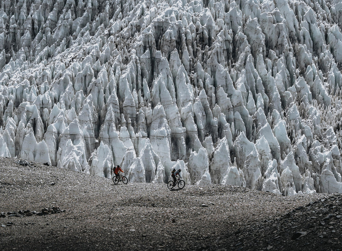 Two mountain bikers riding beside tall ice formations in Trickstuff Piccola HD Titanium campaign imagery.